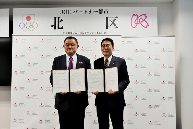 写真：協定書を持って記念撮影する関係者ら