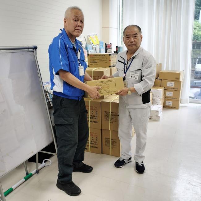 写真:加藤戸沢村長に物資を手渡す松田危機管理室長
