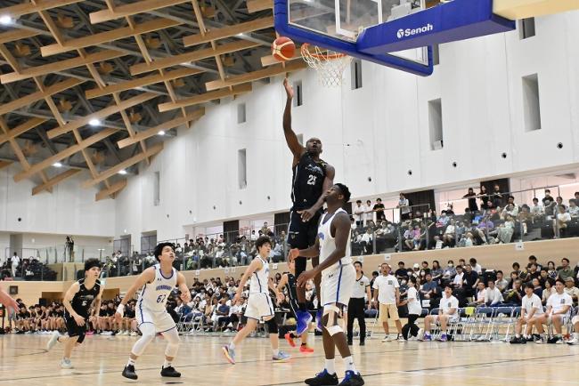 写真:シュートを決めるバスケットボール選手