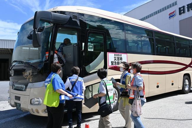写真:日本製紙物流倉庫前からバスに乗車する訓練者の様子