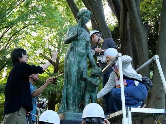 写真:銅像を洗剤で洗浄する人たち