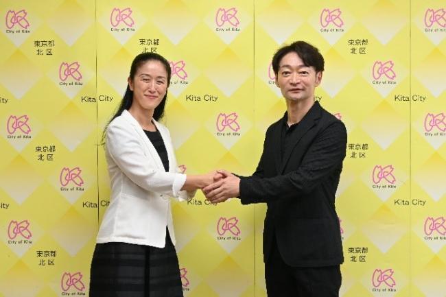 写真:握手して記念撮影する区長とアドバイザー