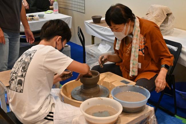 写真:ろくろで陶器を作る小学生