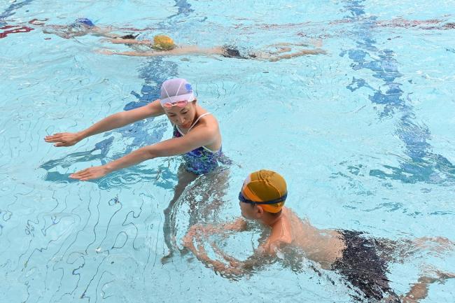 写真:プールで児童に水泳の指導をするオリンピアン