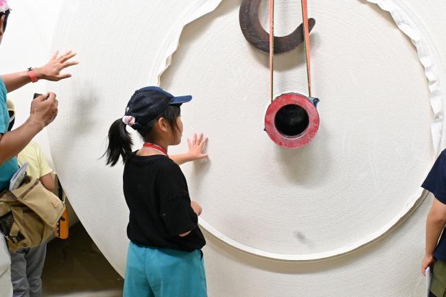 写真:再生紙のロールを触る児童