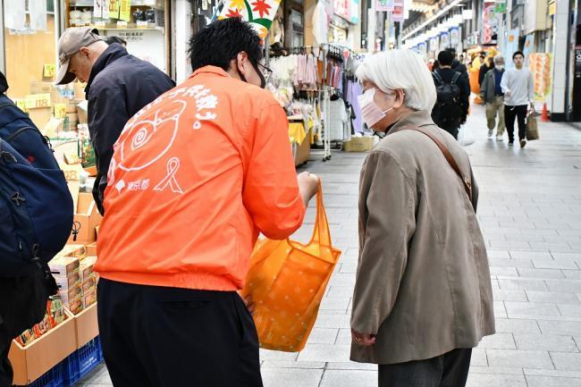 写真：商店街での高齢者へのリーフレット配布