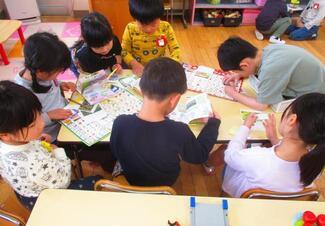 見つけた虫を調べ、図鑑を作っている写真