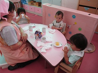 0歳児 午後のおやつを食べたり牛乳とお茶を飲んだりしています。