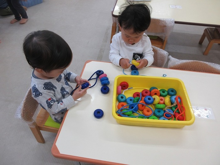 ひも通しで遊んでいる様子の写真