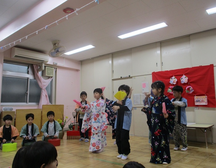 うれしいひなまつりの曲に合わせて5歳児が踊ったり太鼓を叩いたりしている様子です。