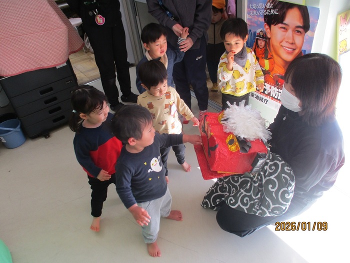 子どもが獅子舞に噛んでもらっている様子