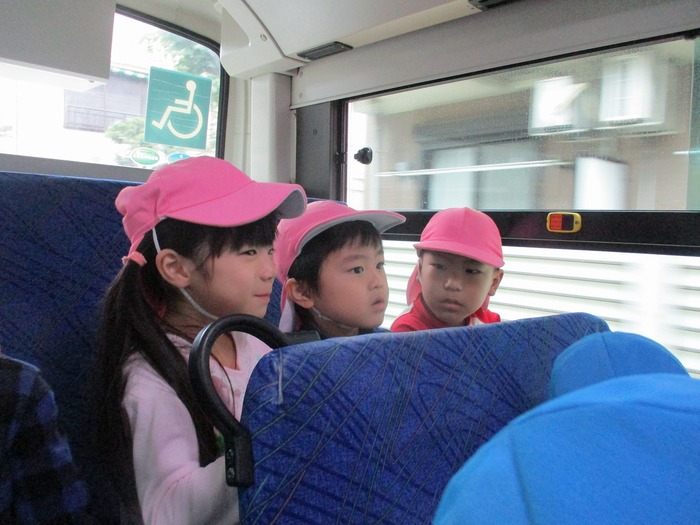 子ども同士隣り合ってバスに乗っているところ