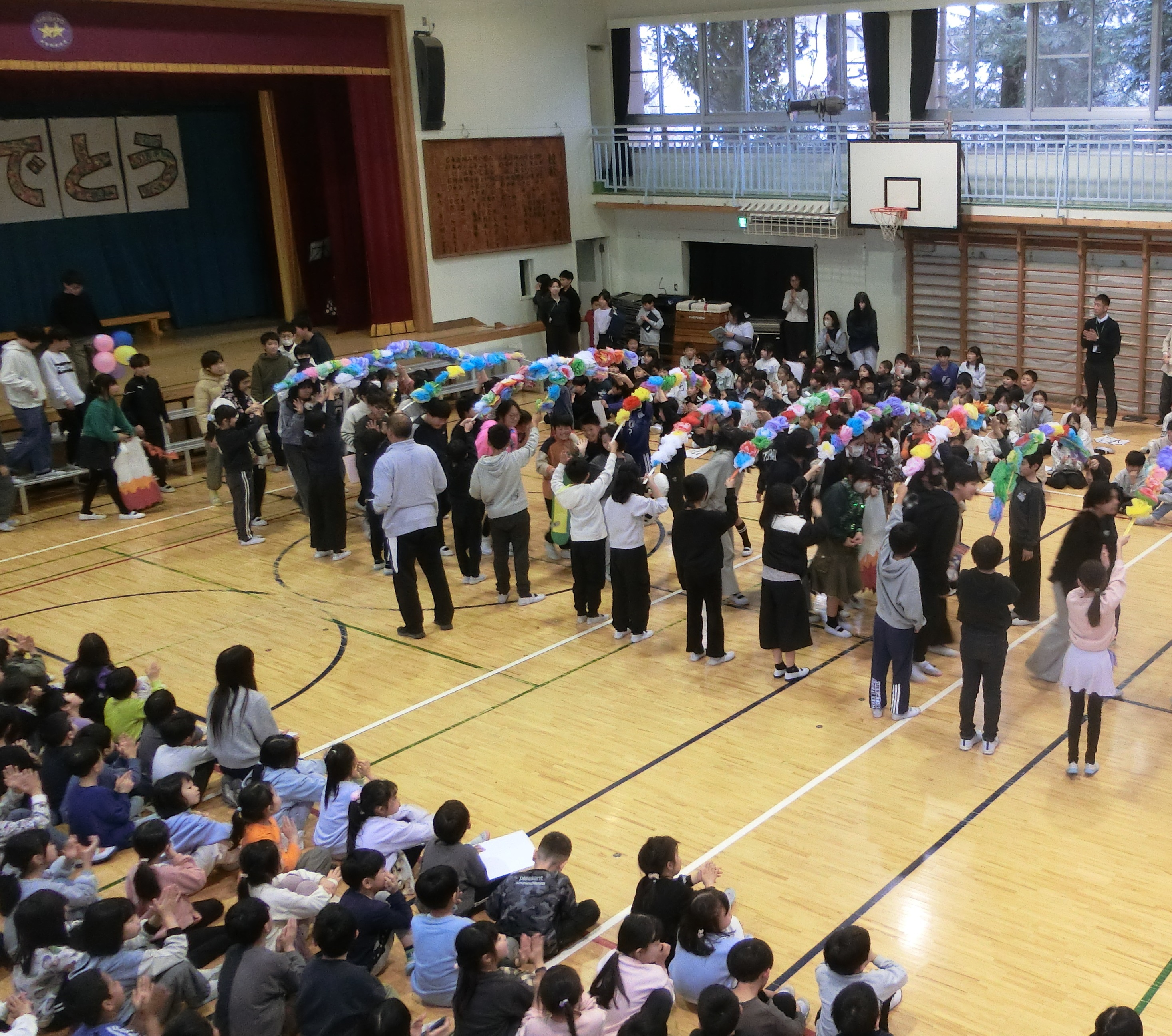 花のアーチを6年生退場