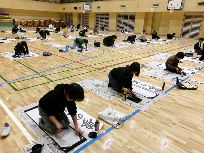 体育館で書き初めをする6年生の様子