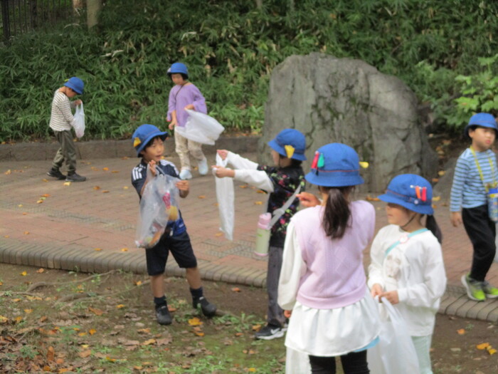 拾ったどんぐりやまつぼっくりを見せ合いっこしている様子