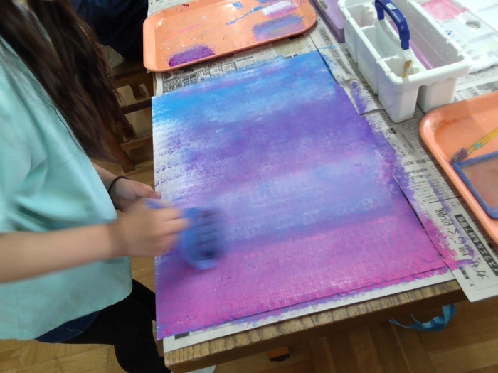 ローラーで画用紙を塗る様子。