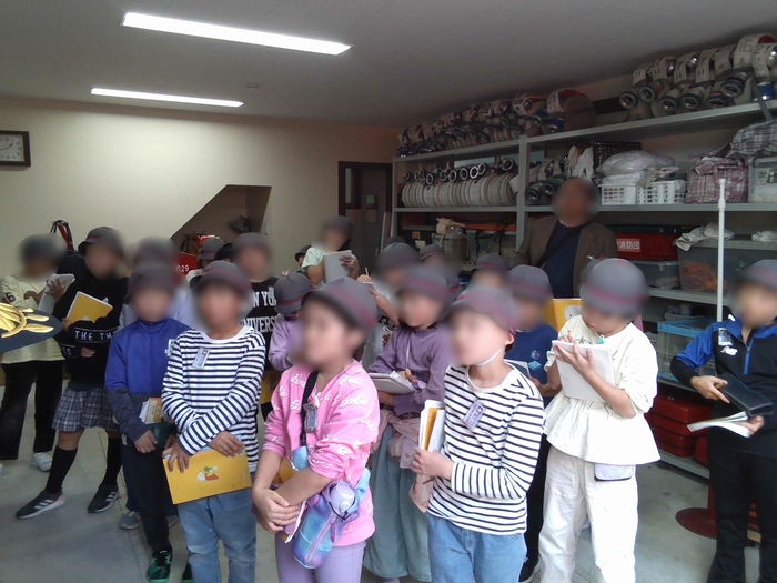 児童が消防団の方の説明を聞いている様子1