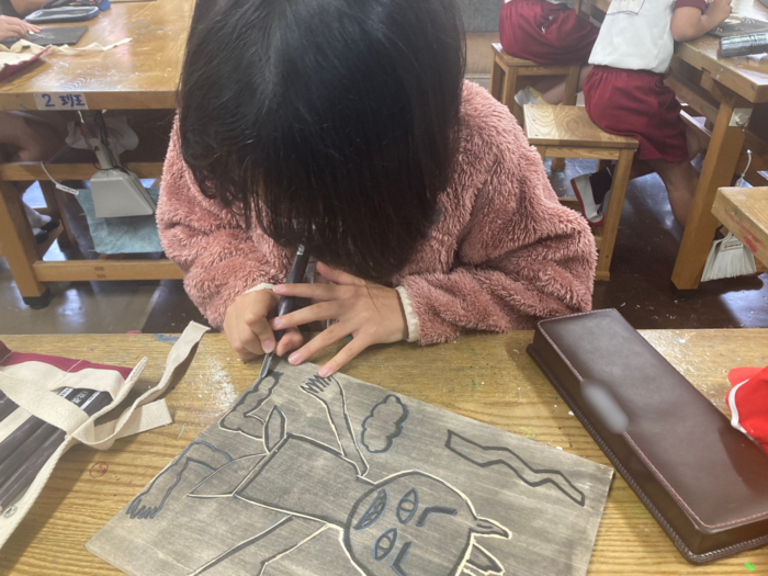 児童が彫刻刀を使って版画を制作している様子。
