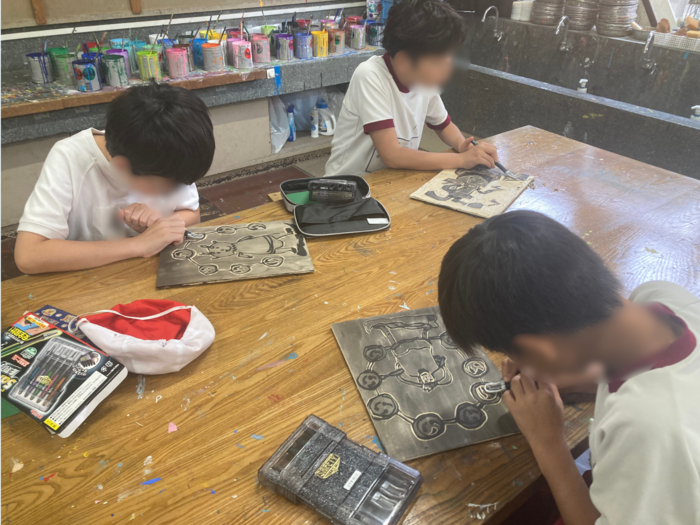 児童が彫刻刀を使って版画を制作している様子。