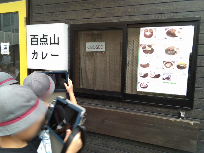 児童がお店の外観をきたコンで撮影している様子