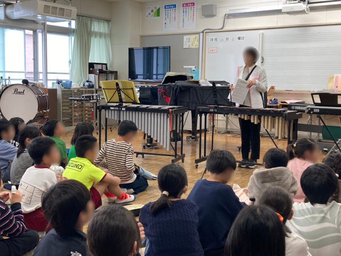 音楽室で音楽の先生から説明を受けている様子