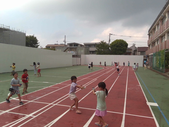 児童が校庭で水遊びをしている様子