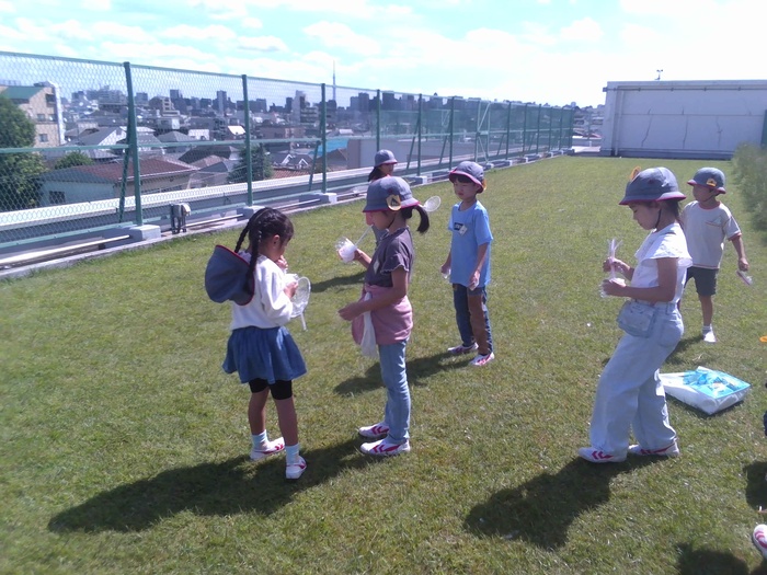 児童が屋上でシャボン玉遊びをしている様子