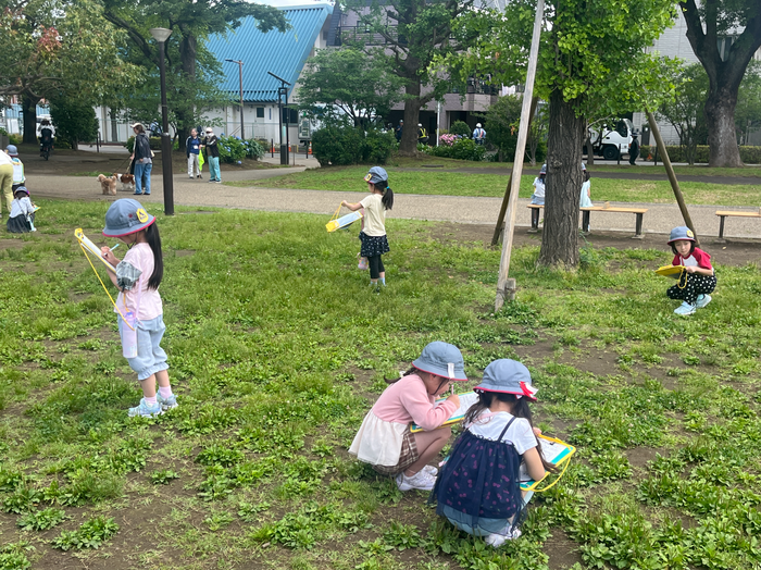 児童が公園で春を探している様子