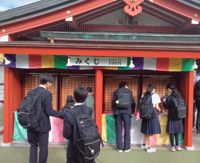 浅草寺でおみくじを引く生徒の様子