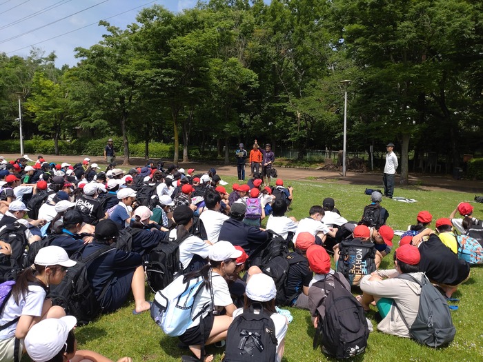 公園で説明を聞いている児童生徒