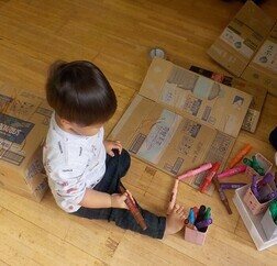 段ボールにペンで絵を描く子ども