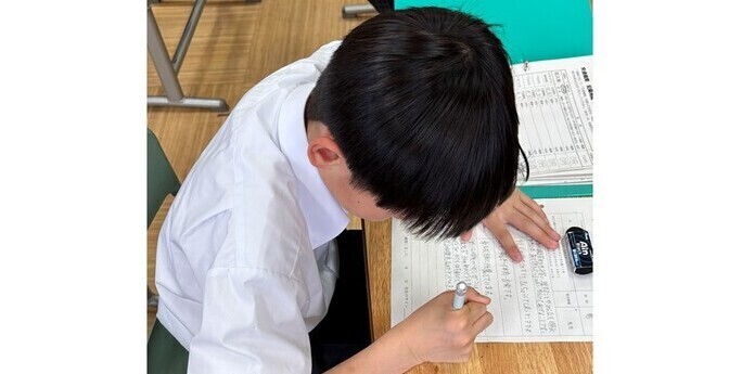自己紹介カードをかいている様子