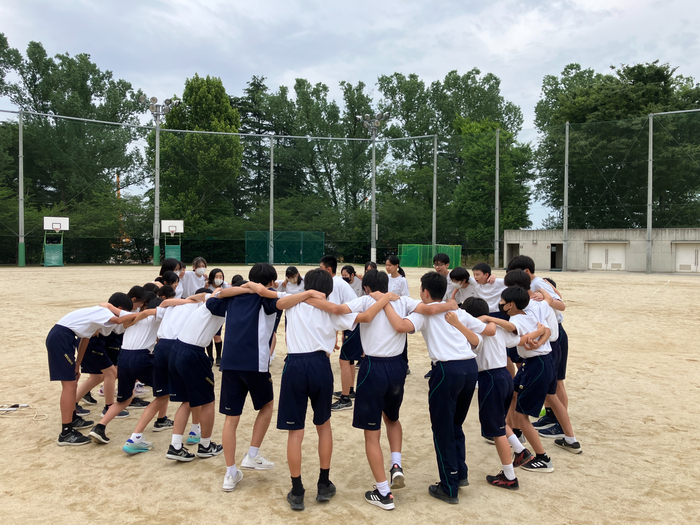 校庭で円陣を組む様子