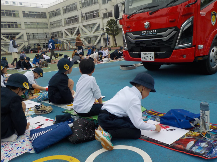 消防車を見ながら絵をかいているようす