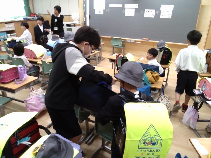 1年生の朝のしたくの手伝いを6年生がしている様子です。