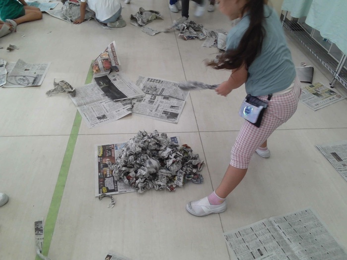 新聞紙で遊ぶ様子。