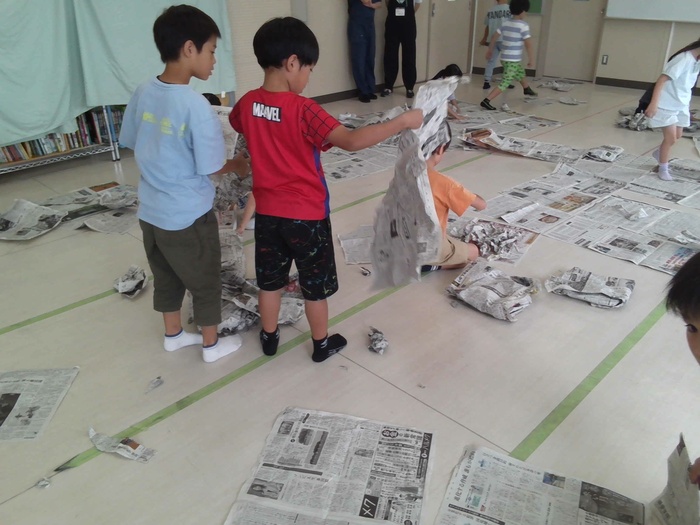新聞紙で試しながら遊ぶ様子。