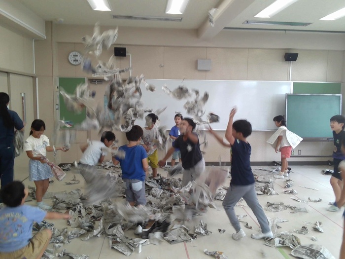 新聞紙をとばして遊ぶ様子。
